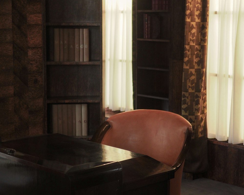 Sala do escritório com estantes de livros e mesa de madeira